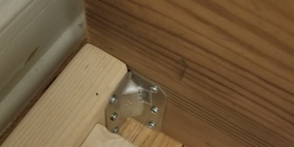 gusset angle tie connecting header and frame on interior